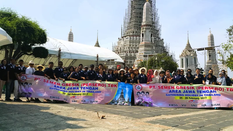 Grup perjalanan Ruhens dengan spanduk Semen Gresik di depan kompleks candi di Thailand.