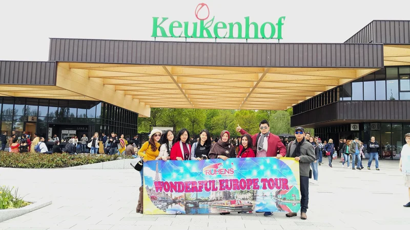 Grup keluarga memegang spanduk Ruhens di depan pintu masuk Keukenhof.